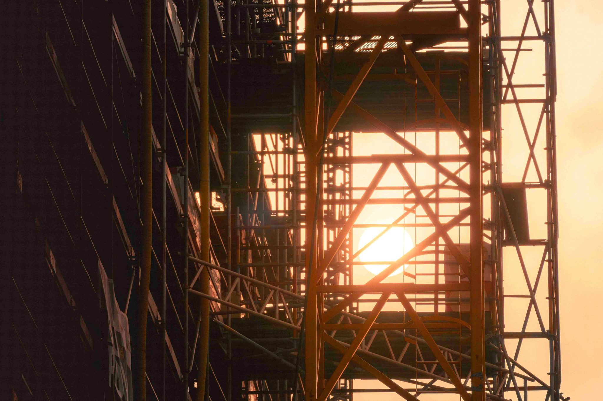 Steel scaffolding lit by a low sun